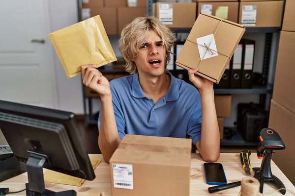 Young Man Working Small Business Ecommerce Holding Packages Clueless Confused — Stockfoto