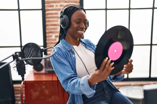 非洲裔美国女艺术家笑着自信地在音乐工作室拿着乙烯唱片 — 图库照片