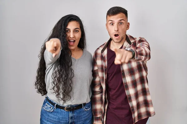 Young Hispanic Couple Standing White Background Pointing Finger Surprised Ahead — Stock Photo, Image