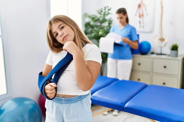 Blonde Little Girl Wearing Arm Sling Rehabilitation Clinic Serious Face — Stockfoto