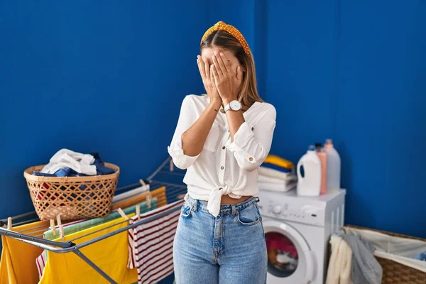 Young Blonde Woman Laundry Room Sad Expression Covering Face Hands — Stock Photo, Image