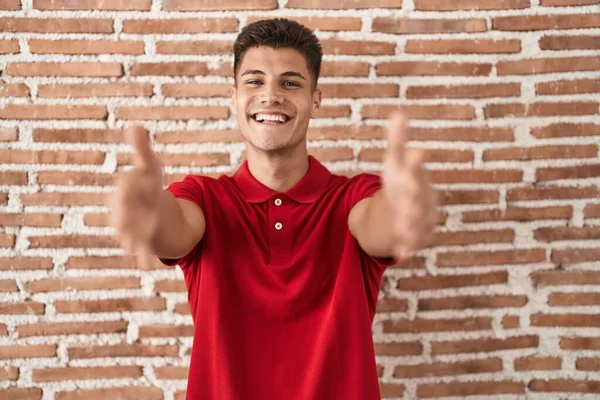 Young Hispanic Man Standing Bricks Wall Looking Camera Smiling Open —  Fotos de Stock