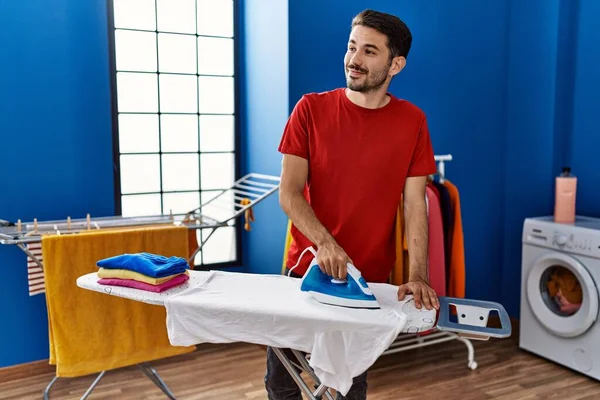 Mladý Hispánec Muž Usměvavý Sebevědomě Žehlící Oblečení Prádelně — Stock fotografie
