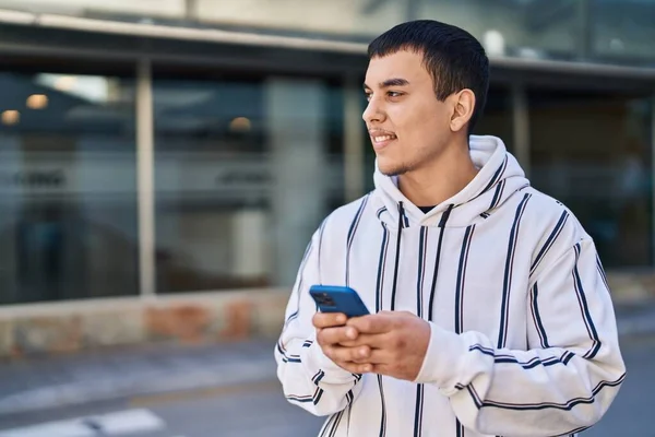 年轻人在街上用智能手机充满自信地微笑 — 图库照片