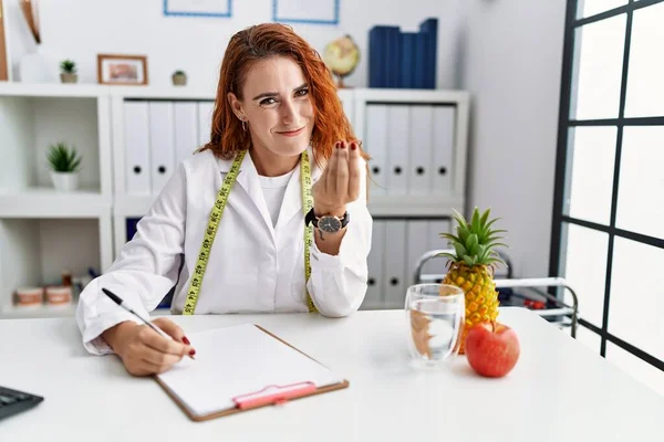 Young Redhead Woman Nutritionist Doctor Clinic Doing Money Gesture Hands — Stock Photo, Image