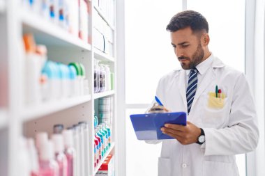 Genç İspanyol eczacı eczanedeki belgeye yazı yazıyor.