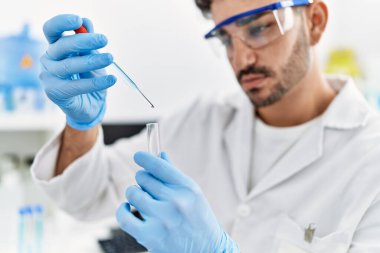 Laboratuvarda bilimsel deney tüpü olarak çalışan yakışıklı İspanyol.