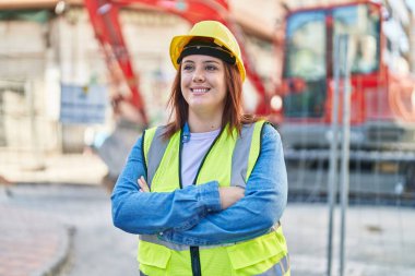 Young beautiful plus size woman architect smiling confident standing with arms crossed gesture at street