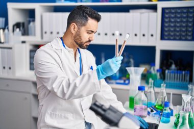 Laboratuvarda test tüpleri tutan genç İspanyol bilim adamı.