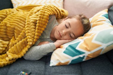 Adorable toddler lying on sofa sleeping at home