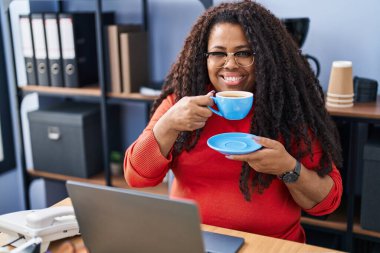 African american woman business worker using laptop drinking coffee at office