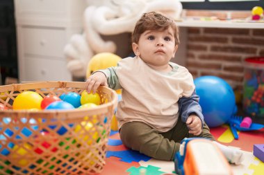 Sevimli İspanyol çocuk anaokulunda yerde oturmuş hayalarıyla oynuyor.