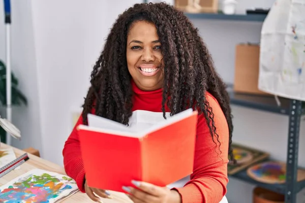 African American Woman Artist Smiling Confident Reading Book Art Studio — ストック写真