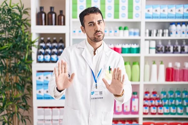 Handsome Hispanic Man Working Pharmacy Drugstore Moving Away Hands Palms — Zdjęcie stockowe