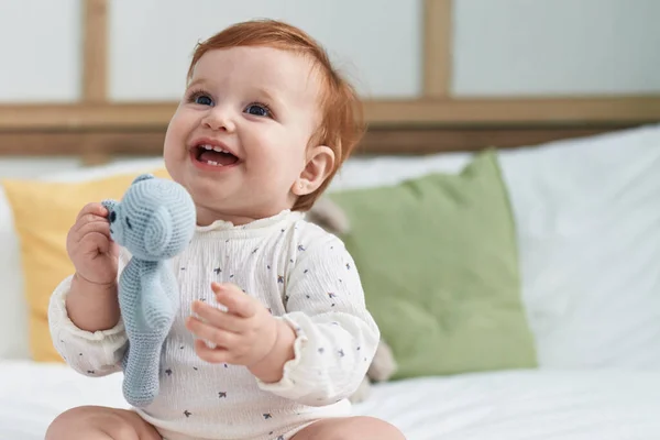 Liebenswert Rotschopf Kleinkind Holding Puppe Sitzen Auf Bett Schlafzimmer — Stockfoto