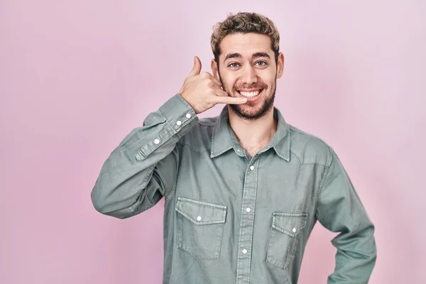 Hispanic Man Beard Standing Pink Background Smiling Doing Phone Gesture — Stockfoto