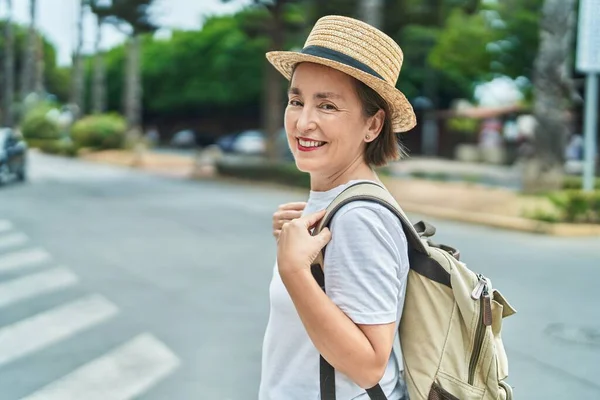 中年妇女游客面带微笑 自信地背着背包走在街上 — 图库照片