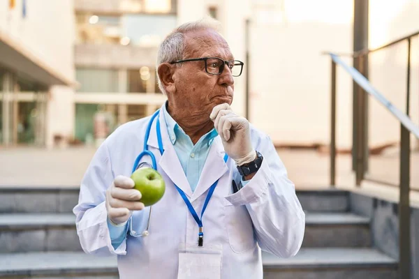 Starszy Lekarz Siwymi Włosami Trzymający Zdrowe Zielone Jabłko Poważna Twarz — Zdjęcie stockowe