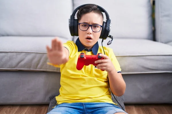 Young Hispanic Kid Playing Video Game Holding Controller Wearing Headphones — Photo