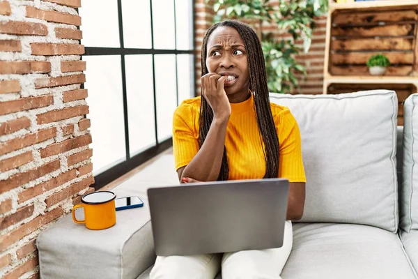 Африканская Женщина Сидит Диване Используя Ноутбук Дома Выглядит Напряженным Нервным — стоковое фото