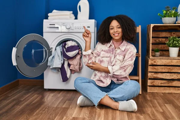 Young African American Woman Sitting Floor Doing Laundry Smiling Happy — ストック写真