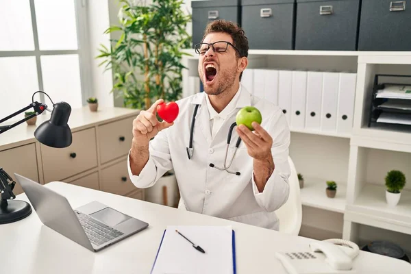 Young Hispanic Man Working Dietitian Clinic Angry Mad Screaming Frustrated — Stock Photo, Image