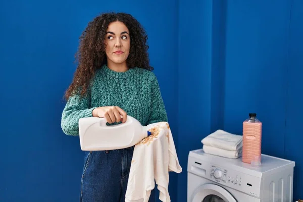 Ung Latinamerikansk Kvinna Håller Smutsig Tvätt Och Tvättmedel Flaska Ler — Stockfoto