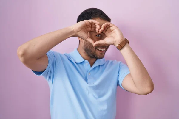 Homem Hispânico Sobre Fundo Rosa Fazendo Forma Coração Com Mão — Fotografia de Stock