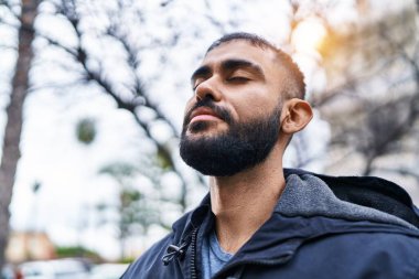 Sokakta gözleri kapalı nefes alan genç bir İspanyol.