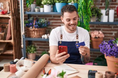 Çiçekçide akıllı telefon kullanan İspanyol bir çiçekçi.