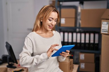 Genç kadın ecommerce busines işçisi ofiste çalışan touchpad kullanıyor.