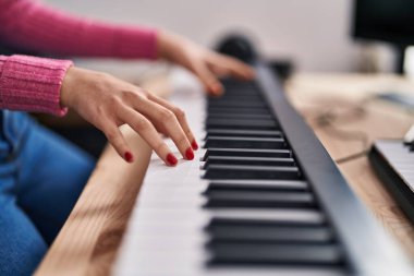 Young caucasian woman musician playing piano at music studio