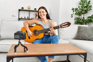 Evinde klasik gitar çalan genç ve güzel bir İspanyol kadın.