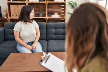 Hispanic girl with down syndrome doing therapy looking to side, relax profile pose with natural face with confident smile. 