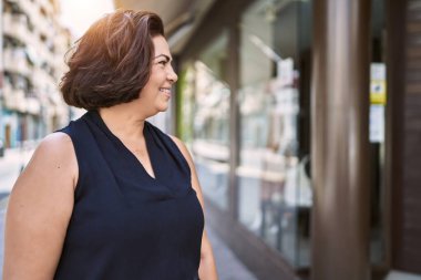 Güneşli bir günde mutlu ve kendinden emin gülümseyen orta yaşlı İspanyol kadın.