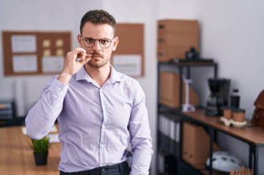 Ofisteki genç İspanyol adam ağzı ve dudakları parmaklarıyla fermuar gibi kapalı. gizli ve sessiz, tabu konuşması 