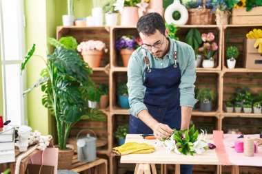 Çiçekçide çiçek buketi yapan genç bir İspanyol.