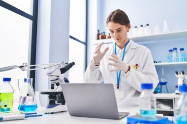 Young caucasian woman scientist having video call at laboratory