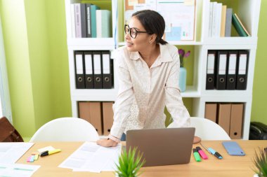 Young arab woman business worker smiling confident standing by desk at office