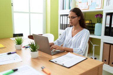Ofiste çalışan genç Afro-Amerikan iş kadını laptopu kullanıyor.