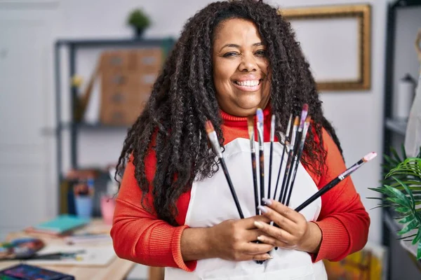 African American Woman Artist Smiling Confident Holding Paintbrushes Art Studio — Photo