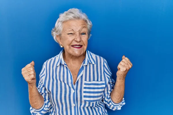 Mavi Arka Planda Gri Saçlı Yaşlı Bir Kadın Kolları Havada — Stok fotoğraf