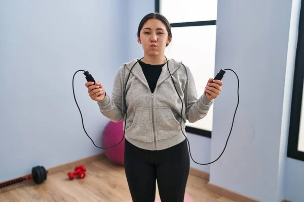 Young Latin Woman Jumping Skipping Rope Puffing Cheeks Funny Face — Stockfoto