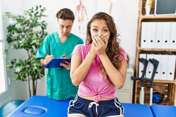 Young Hispanic Woman Physiotherapist Appointment Shocked Covering Mouth Hands Mistake — Stockfoto