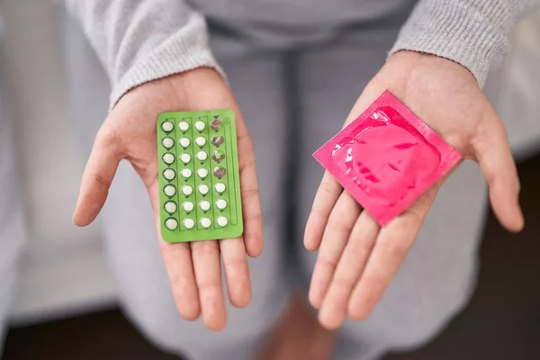 Young Beautiful Size Woman Holding Birth Control Pills Condom Home — Stockfoto