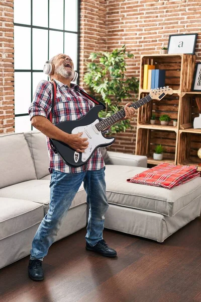 Homem Cabelos Grisalhos Sênior Cantando Música Tocando Guitarra Elétrica Casa — Fotografia de Stock