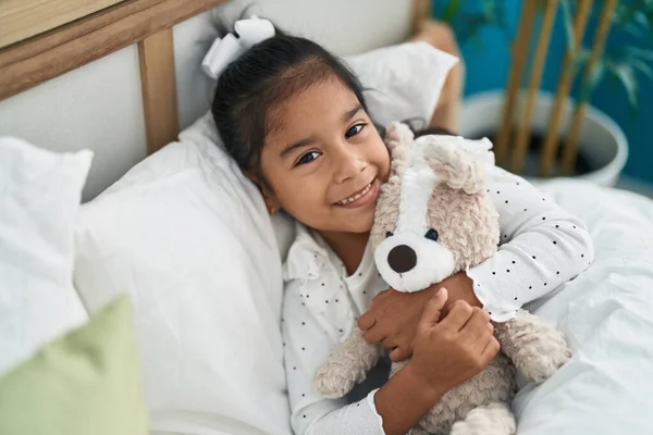 可爱的惊恐女孩抱着泰迪熊躺在卧室的床上 — 图库照片