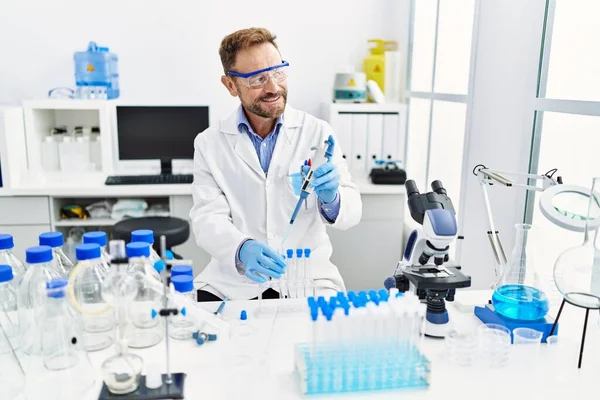 Orta yaşlı, labaratuarda çalışan bilim adamı üniforması giyen bir İspanyol.