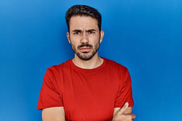 Young Hispanic Man Beard Wearing Red Shirt Blue Background Skeptic — Stok fotoğraf