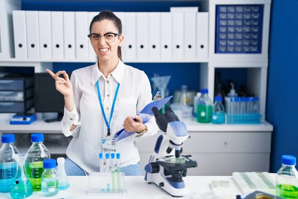 Young Brunette Woman Working Scientist Laboratory Pointing Aside Worried Nervous — Stockfoto